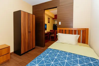 a small bedroom with a bed and a desk at Sunlit Makati Haven Cozy 1BR Gym Pool 1703 in Manila