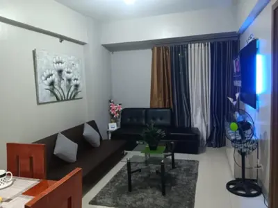 a living room with a couch and a table at M&N Condotel in Manila