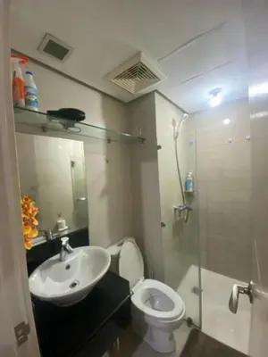 a bathroom with a toilet and a sink and a shower at M&N Condotel in Manila