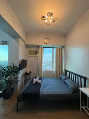 a bedroom with a bed with a large window at Peaceful Getaway in Manila
