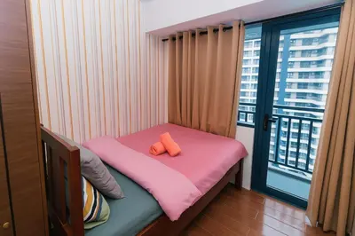 a small bed with a pink blanket and a window at Serene Stay Air Makati Boutique Comfort City Perks 1767 in Manila