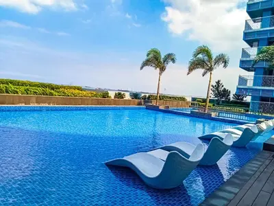 a swimming pool with blue water and palm trees at Luxury 3BR near Solaire, Airport II Infinity Pool in Manila