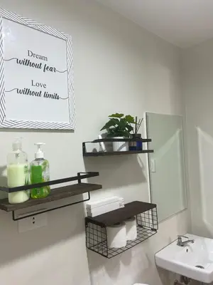 a bathroom with a sink and a toilet and a mirror at The Minimal Getaway in Manila
