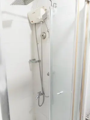 a shower in a bathroom with a glass door at Maria's staycation in Manila
