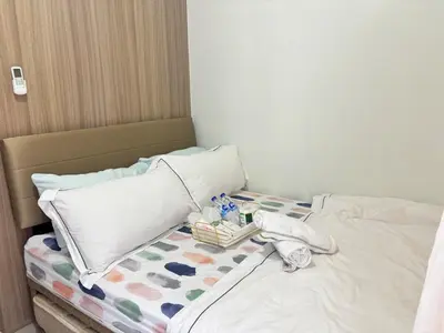a bed with two pillows and a tray on it at Cozy Condo Near MOA & Airport in Manila