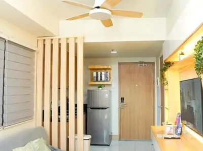 a living room with a ceiling fan and a refrigerator at Awsome Corner Unit at Shore 3 in Manila