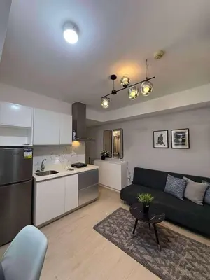 a living room with a couch and a kitchen at Azure Residences Penthouse in Manila