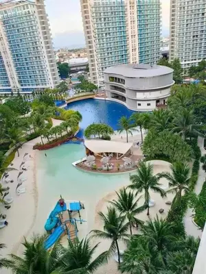 a large swimming pool in a resort with tall buildings at Dream Catcher Theme Unit in Manila