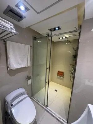 a bathroom with a glass shower and a toilet at 4 Bedroom Luxury Condo in Ortigas in Manila