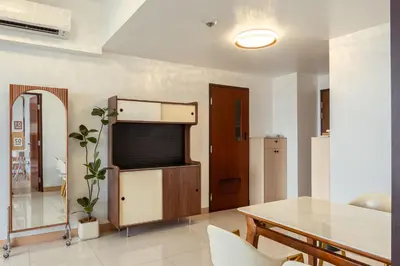 a living room with a table and a television at Premium 2 Bedroom and 1 Living Room Suite with Balcony - One Uptown, BGC in Manila