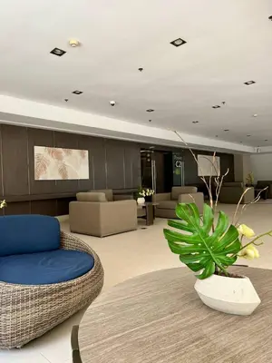 a living room with a couch and a chair and a table at Casa JYD at Shore Residences - Mall of Asia in Manila
