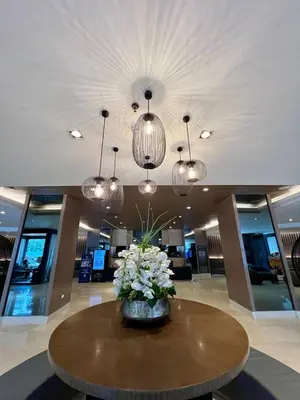 a lobby with a table with flowers and chandeliers at Casa JYD at Shore Residences - Mall of Asia in Manila