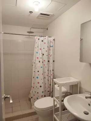 a bathroom with a toilet and a shower curtain at The Intramuros Suite in Manila