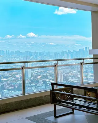 a bench in a room with a view of a city at The Intramuros Family Suite in Manila