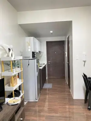 a kitchen with a refrigerator and a table in it at Air Residences in Manila