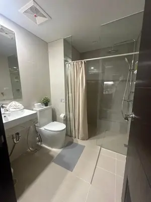 a bathroom with a shower and a toilet and a sink at TravelersChoiceCondominium in Manila