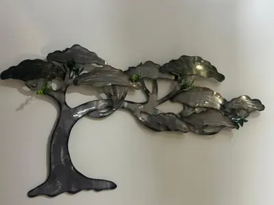 a bronze sculpture of a tree on a wall at TravelersChoiceCondominium in Manila
