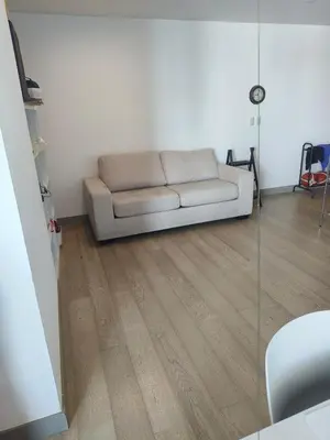 a white couch in a living room with a wooden floor at In the City in Manila