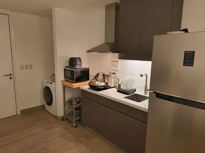 a small kitchen with a sink and a refrigerator at In the City in Manila
