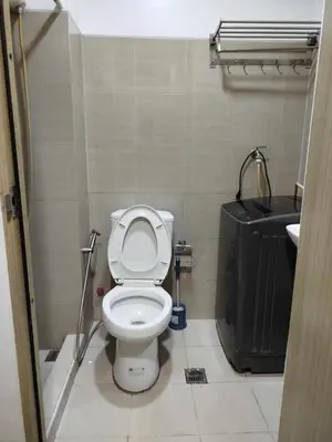 a small bathroom with a toilet and a sink at La Vie Riche Holiday Homes - Cozy 1BR Apartment near MOA in Manila