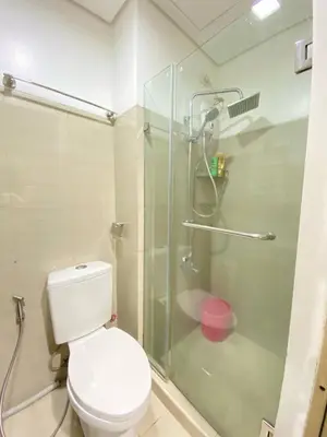 a bathroom with a toilet and a glass shower at Blytheo Urban Staycation by Jonathan in Manila