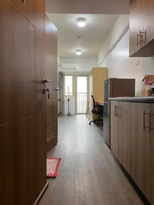 a kitchen with wooden cabinets and a door in a room at FX Property 3950 in Manila