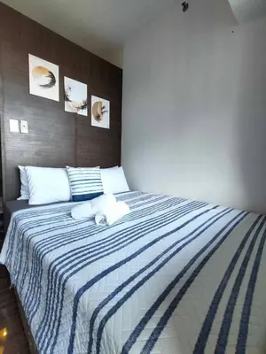 a bedroom with a blue and white striped bed at Comfortable & Peaceful for You #4806 in Manila