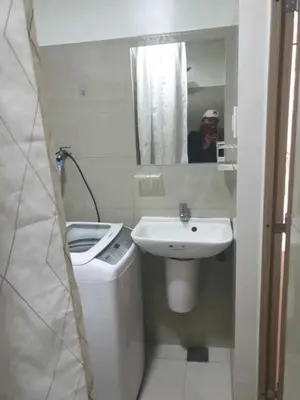 a bathroom with a sink and a toilet and a mirror at Shore 2 tower 2 in Manila