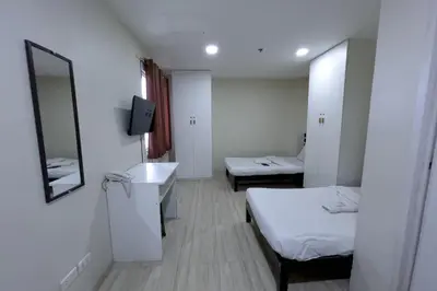 a small room with two beds and a mirror at Jardin Oriental Suites Ubelt Manila in Manila