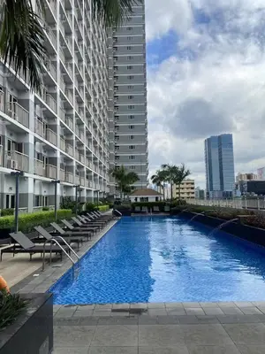 a large swimming pool with chairs and a building at FX Property 3926 in Manila