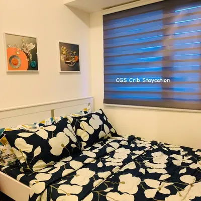 a bedroom with a bed and a window with a ccs crib suspension at CGS Crib staycation in Manila