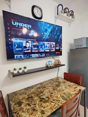 a large flat screen tv hanging on a wall at Staycationsite at Sea Residences in Manila