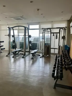 a gym with several tread machines in a room at High and Cozy in Manila