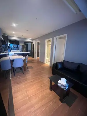 a living room with a black couch and a table at Knightsbridge Residences in Manila