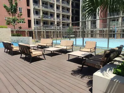 a group of chairs and tables next to a swimming pool at WS906 Condo near Moa, Free Pool Access in Manila