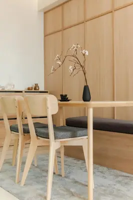 a dining room table with two chairs and a vase with flowers at Eastwood City 1BR Muji Home Luxe Minimalist Fast WiFi in Manila