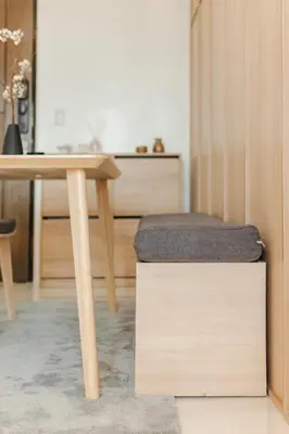 a wooden table with a stool and a table with a desk at Eastwood City 1BR Muji Home Luxe Minimalist Fast WiFi in Manila