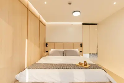 a bedroom with a bed with a pair of shoes on it at Eastwood City 1BR Muji Home Luxe Minimalist Fast WiFi in Manila