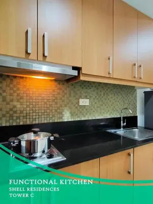 a kitchen with wooden cabinets and a sink at GV Holiday Homes - Shell Residences MOA - Cozy 1BR Apartment in Manila