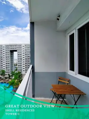 a balcony with a wooden bench and a table at GV Holiday Homes - Shell Residences MOA - Cozy 1BR Apartment in Manila