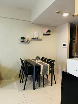 a dining room with a black table and chairs at Studio Unit in One Palm Tree Villas across NAIA Terminal 3 in Manila