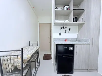 a small kitchen with a sink next to a bed at Urban Deca Towers Cubao in Manila