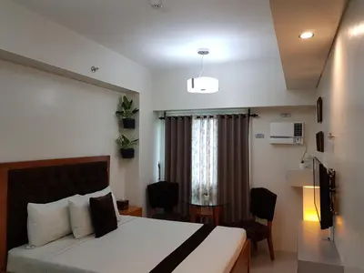 a hotel room with a bed and a table and chairs at Studio Unit at The Beacon Makati in Manila