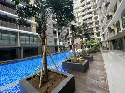 a pool in the middle of a building with palm trees at 1BR with Queen Bed and Balcony, Walk to Okada in Manila