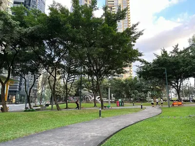 a walkway in a park with trees and buildings at Spacious 1BR Condo with 300mbps WiFi in BGC in Manila