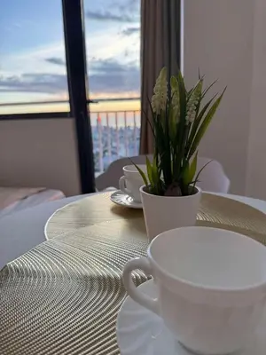 a table with a cup of coffee and a plant on it at Casa Aotea in Sampong