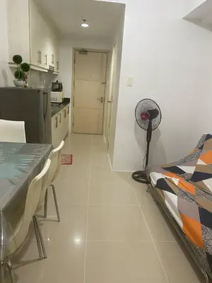 a kitchen with a table and a chair in a room at Janas Condotel in Manila