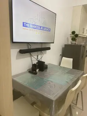 a television hanging on a wall above a table at Janas Condotel in Manila