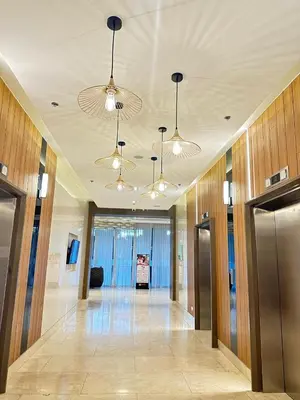an empty hallway in a building with chandeliers at Casa De Ciudad - Shore Residences MOA PASAY in Manila