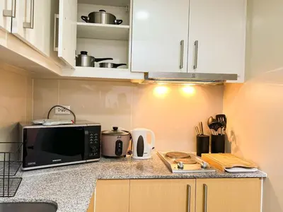 a kitchen with a counter top with a microwave at Prime Uptown BGC | Stylish 1BR Getaway #upt1 35j in Manila